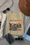 Beige Vipaniq classic T-shirt featuring the Breakfast 120 KM Away road and rider graphic on the front.